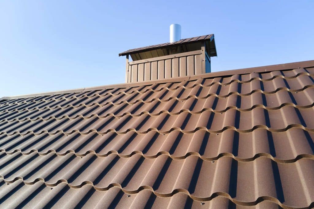 Close-up of brown metal roofing with a chimney