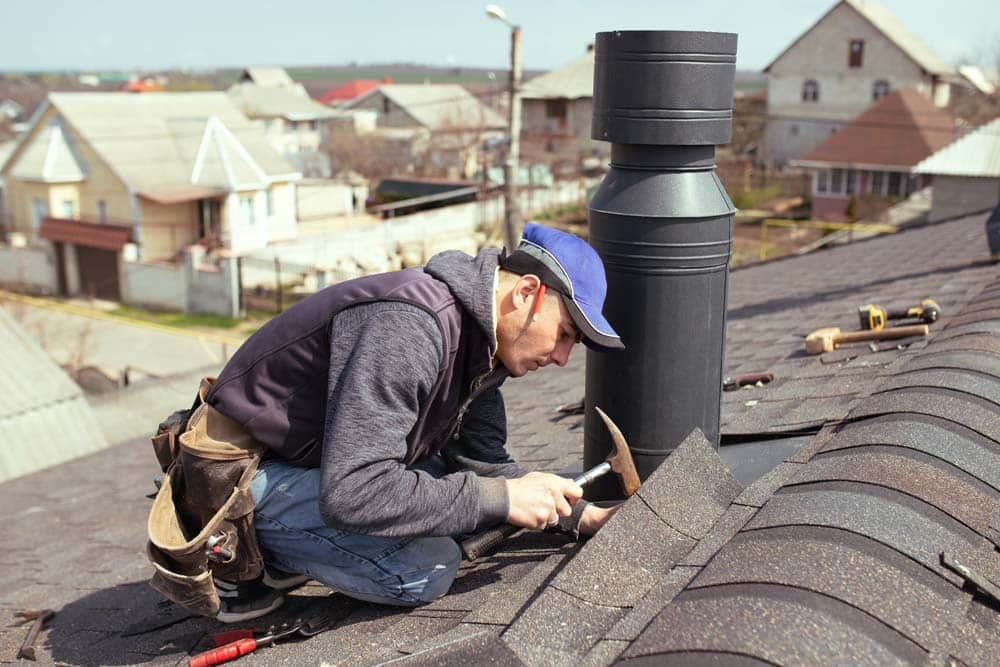 A professional roofer is repairing some damages in a roofing system